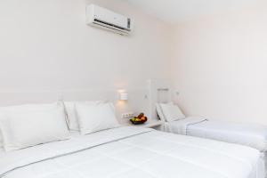 two beds in a room with white walls at Golden Sand in Plaka