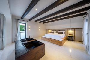 una camera da letto con un letto grande e una vasca da bagno di House of Petra a Jimbaran