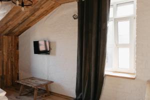 a room with a window and a tv on a wall at Hotel Dynasty in Kamianets-Podilskyi