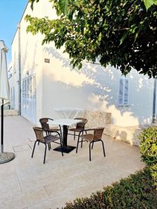 een patio met een tafel en stoelen naast een gebouw bij Residence-Apartment-Giuliano-Punta Skala in Petrcane