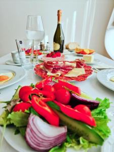 een tafel met borden en een fles wijn bij Residence-Apartment-Giuliano-Punta Skala in Petrcane