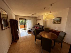 ein Wohnzimmer mit einem Tisch und einem Sofa in der Unterkunft PV34, Apartamento cerca mar con piscina parking in Villajoyosa