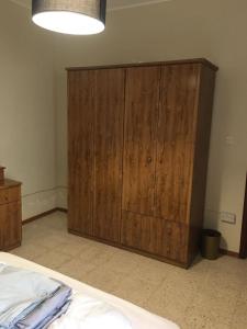 a large wooden cabinet in a room with a bed at Luxery Apartment in Tuzla