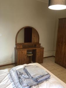 a bedroom with a bed with a desk and a mirror at Luxery Apartment in Tuzla