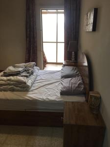 an unmade bed with a window in a bedroom at Luxery Apartment in Tuzla