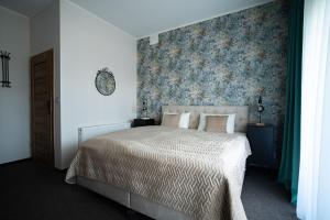 um quarto com uma cama com papel de parede floral em Villa Sinaloa-Spa em Ruda Śląska