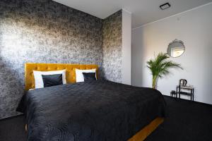 sypialnia z czarnym łóżkiem z żółtym zagłówkiem w obiekcie Villa Sinaloa-Spa w Rudzie Śląskiej
