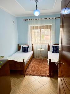 佩爾梅特的住宿－Guest House Dimos Kristi，一间卧室设有两张床和窗户。