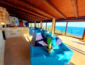 una sala de estar con sofás azules y un cactus en Ferienhaus mit Terrassen und traumhaftem Blick aufs Meer, en Otranto