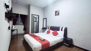 a bedroom with a large bed with red pillows at Hotel Rasa Sayang 2 in Tanah Rata