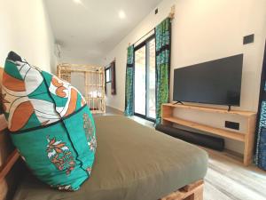 ein Wohnzimmer mit einem Flachbild-TV und einem Sofa in der Unterkunft Skippers - Adults only in Ukunda