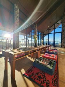 努沃勒埃利耶Villa Crosswinds Nuwara Eliya的房间里有一张长木桌，上面有几张垫子