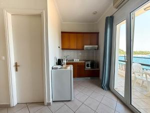 a kitchen with a refrigerator and a balcony at Imerolia Studios in Kassiopi