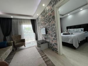 a bedroom with a bed and a stone wall at Gardenya Lara Suit Hotel in Antalya