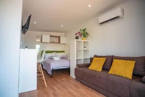uma sala de estar com um sofá e um quarto em Mobilheim für 3 Personen ca 20 qm in Ugljan, Dalmatien Inseln vor Zadar em Ugljan