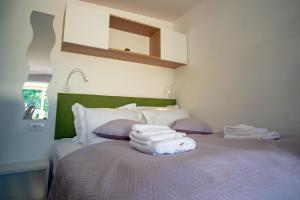 um quarto com uma cama com toalhas em Mobilheim für 3 Personen ca 20 qm in Ugljan, Dalmatien Inseln vor Zadar em Ugljan