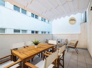 a dining room with a wooden table and chairs at Magno Apartments San Martín Terrace in Seville