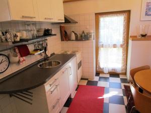 eine kleine Küche mit einem Waschbecken und einem roten Teppich in der Unterkunft Studio für 2 Personen ca 75 qm in Bessenbach, Bayern Franken in Straßbessenbach