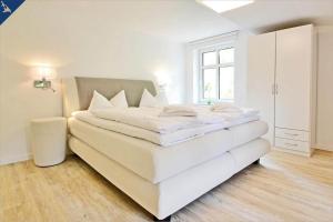 uma grande cama branca num quarto com uma janela em Apartment Martha 1 em Heringsdorf