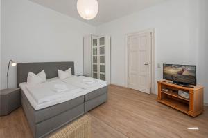 een slaapkamer met een groot bed en een televisie bij Apartment Martha 2 in Heringsdorf