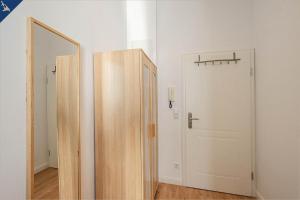 een kamer met 2 houten deuren en een spiegel bij Apartment Martha 2 in Heringsdorf