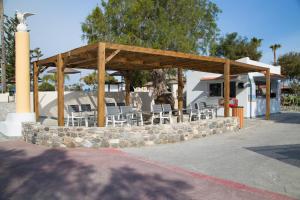 a wooden pavilion with chairs and a stone wall at Atlantis Hotel in Kos Town