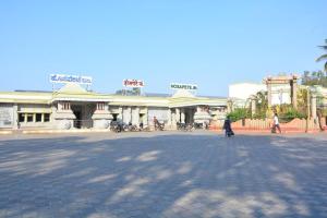 a person walking in a plaza in front of a building at Irctc Hotel in Hospet