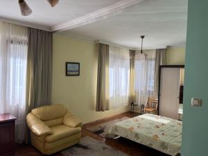 - une chambre avec un lit, un canapé et une chaise dans l'établissement При Bond-100 м/2 със градина, à Bourgas