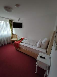 um quarto de hotel com uma cama e uma mesa em Room in Guest room - Comfortable single room with shared bathroom and kitchen em Forbach