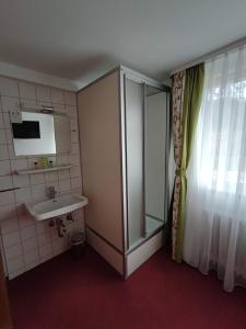 uma casa de banho com um lavatório e um chuveiro em Room in Guest room - Comfortable single room with shared bathroom and kitchen em Forbach