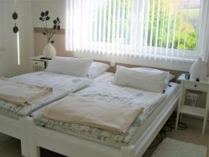 - 2 lits blancs dans une chambre avec fenêtre dans l'établissement Wohnung in Trubenhausen mit Grill, Terrasse und Garten, à Trubenhausen
