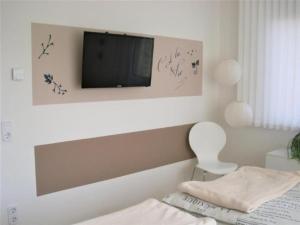 um quarto com uma cama e uma televisão na parede em Wohnung in Trubenhausen mit Grill, Terrasse und Garten em Trubenhausen