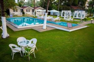 an overhead view of a pool with chairs and a table at Seawood Beachfront Resort in Morjim