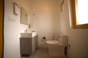 ein Badezimmer mit einer weißen Toilette und einem Waschbecken in der Unterkunft Mahantam Luxury Stays in Nagar + 35 Fotos