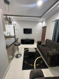 Il comprend un salon doté d'un canapé et d'une télévision à écran plat. dans l'établissement Ranchdale Apartments, à Lusaka