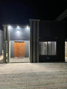 - un bâtiment avec une porte marron et deux fenêtres dans l'établissement Ranchdale Apartments, à Lusaka