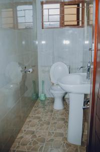 een badkamer met een toilet en een wastafel bij Ranchdale Apartments in Lusaka