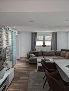 ein Wohnzimmer mit Sofa und Fernseher in der Unterkunft Ferienwohnung Zum Kühlen Grund in Eimelrod