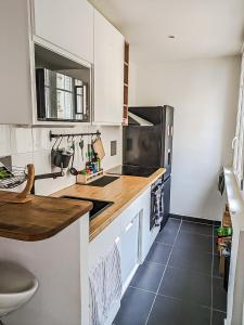 cocina con armarios blancos y encimera en HbyB - 1BR - Coeur Boulogne, en Boulogne-Billancourt