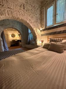 1 dormitorio con 1 cama grande y pared de piedra en Dependance in giardino storico - Oltrarno, en Florencia