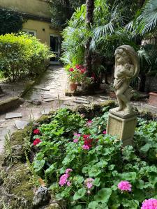 un jardín con una estatua en medio de flores en Dependance in giardino storico - Oltrarno, en Florencia