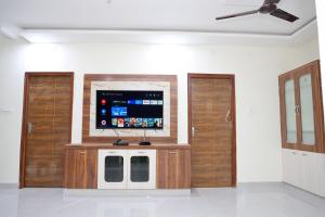 a room with two wooden doors and a flat screen tv at Sun Home Stays in Tirupati