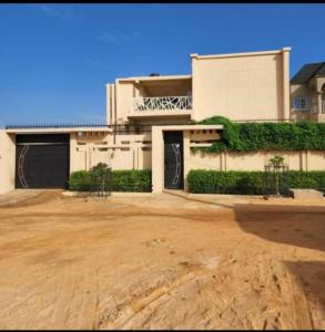 a large white house with a large driveway at Kalinou Niamey in Niamey