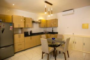 a kitchen with a table and chairs and a refrigerator at Kalinou Niamey in Niamey