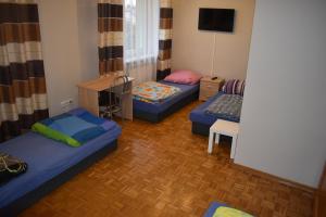 a small room with two beds and a tv at Pokoje Jasionka Zaczernie in Trzebownisko