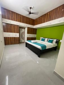 a bedroom with a bed with a green wall at Sun Home Stays in Tirupati
