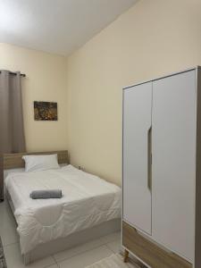 a bedroom with a white bed and a glass closet at Deluxe Rooms in Al Mamzar SHJ Shared bathroom in Sharjah