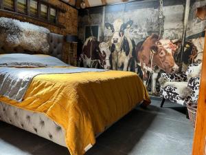 1 dormitorio con 1 cama y un mural de vacas en B&B de Witte Weide, en Nieuwlande