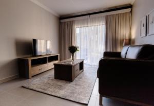 a living room with a couch and a television at Kyalami Creek in Midrand