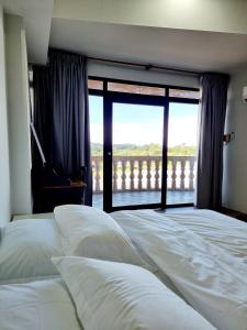 a bedroom with a bed with a view of a balcony at Cozzzy hut Riverbank Suites Kuching with spectacular River view in Kuching +33 photos